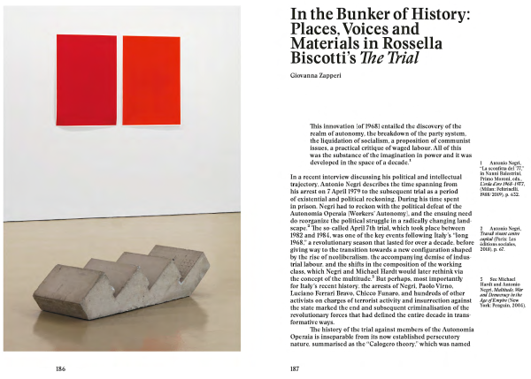 PDF spread, the left page shows an installation shot with a concrete sculpture on the ground, resembling a cut-out staircase laying horizontally rather than proceeding vertically. On the wall, there are two red monochrome prints in different hues, one is darker than the other. The right page features the first page of an essay by author Giovanna Zapperi titled 